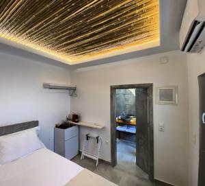 a bedroom with a bed and a desk in a room at AVALON Luxury Suites in Ermoupoli