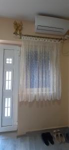 a window with a white curtain and a door at Apartman Kika 1 in Valjevo +28 photos