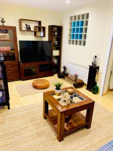 a living room with a coffee table and a flat screen tv at Vivienda turística Porta do Sol in Baiona