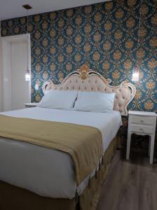 a bedroom with a large bed and a blue wall at Pousada Serrano in Campos do Jordão