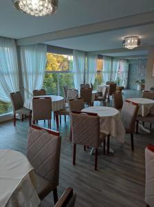 a restaurant with tables and chairs and windows at Pousada Serrano in Campos do Jordão
