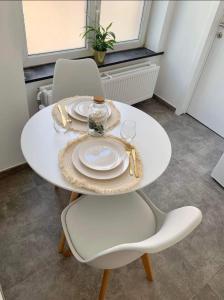 a white table with two chairs and a white plate at Sweet Grey SPA in Liège