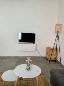 ein Wohnzimmer mit einem weißen Tisch und einem TV in der Unterkunft Sweet Grey SPA in Lüttich