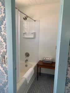 a bathroom with a bath tub and a table at The Bodie Hotel in Bridgeport