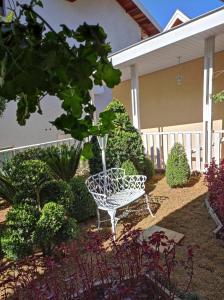 a white bench sitting in the middle of a garden at Pousada Serrano in Campos do Jordão