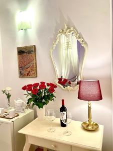 a table with a lamp and a bottle of wine and flowers at Home Milù - Milù Holidays Florence in Florence