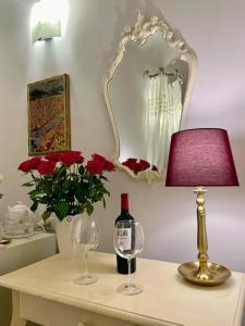 einem Tisch mit einer Lampe und einer Vase mit roten Rosen in der Unterkunft Home Milù Florence in Florenz