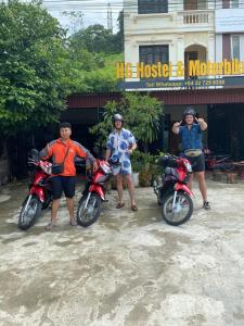 três pessoas de pé ao lado de suas motos em frente a um edifício em HG Hostel and Motorbikes em Ha Giang