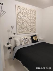 a bedroom with a black bed with a picture on the wall at Winnie's Homestay in Las Palmas de Gran Canaria