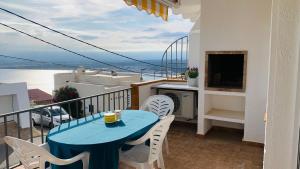 a blue table and chairs on a balcony with a view at La baie de Rose in Roses