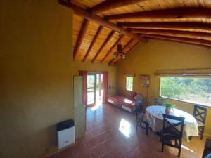 a living room with a table and a couch at Cabaña Esquina Siracusa in Villa Yacanto
