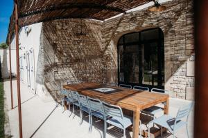 un patio al aire libre con mesa de madera y sillas en Mas des Ecoliers en Châteaurenard