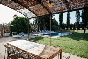 a patio with a table and chairs and a pool at Mas des Ecoliers in Châteaurenard