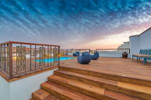 タリファにあるBOMBAYARTE APARTHOTEL TARIFAの階段付きのデッキ、建物内のスイミングプール