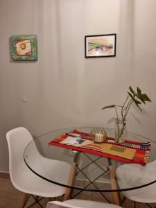 a glass table with two white chairs and a table at Marfil in Posadas