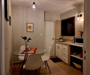 a small kitchen with a table and white chairs at Marfil in Posadas