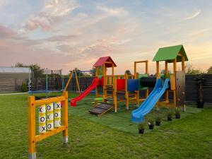 a playground with colorful slides and a slide at Domki Kalimera 3 in Jantar