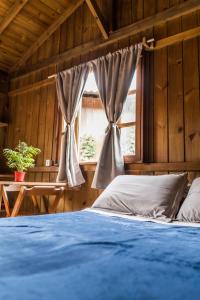 ein Schlafzimmer mit einem blauen Bett und einem Fenster in der Unterkunft Villa Rosa Cabanas in Guarda do Embaú