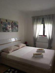 a bedroom with a large bed with two towels on it at Holiday house EMC in Umag
