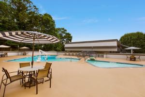 a pool with tables and chairs and an umbrella at Best Western Southlake Inn in Morrow