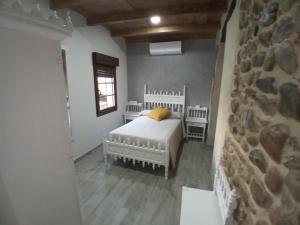 sypialnia z łóżkiem i kamienną ścianą w obiekcie Hostal La Medina de Camponaraya w mieście Camponaraya