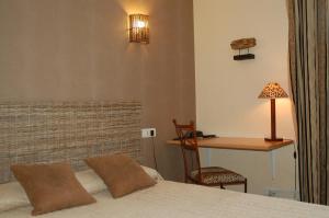 a bedroom with a bed and a desk with a lamp at Hôtel de L'Avenue in Saintes