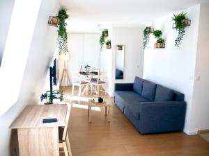 - un salon avec un canapé bleu et une table dans l'établissement Le Petit Soleil de Corbeil, à Corbeil-Essonnes
