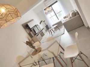a white living room with a table and chairs at PR Apart - Alquileres Temporarios in San Miguel de Tucumán