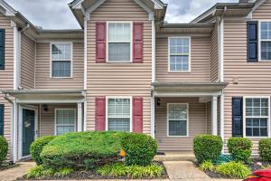 a house with red doors and bushes in front of it at La Vergne Townhome 22 Mi to Dtwn Nashville! in La Vergne