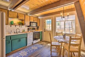 a kitchen with green cabinets and a table and chairs at Pet-Friendly Cottage, Walk From Big Bear Village! in Big Bear Lake