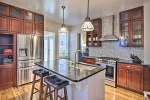 a kitchen with wooden cabinets and a kitchen island with bar stools at Milwaukee Home Less Than Half Mi to Lake Michigan! in Milwaukee