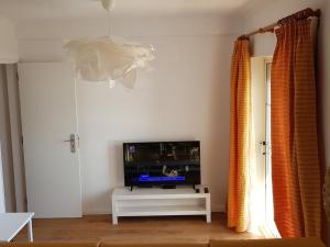 a living room with a tv and a white table at Lagoa Beach & Leisure in Costa de Santo André