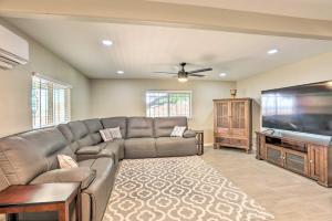 a living room with a couch and a flat screen tv at Tucson Getaway with Private Pool and Gas Grill! in Tucson