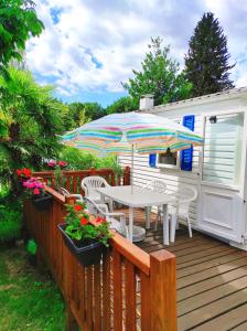 una mesa y sillas en una terraza con sombrilla en Camping Quimper en Quimper