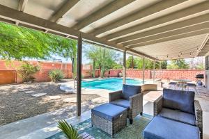 a patio with two chairs and a swimming pool at Tucson Getaway with Private Pool and Gas Grill! in Tucson