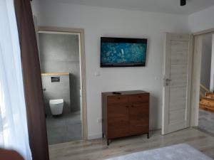 een badkamer met een toilet en een televisie aan de muur bij Dom Hermana in Mrzeżyno +21 foto's