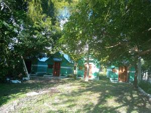 a blue house with trees in front of it at cabañas kukulkan in Xpujil