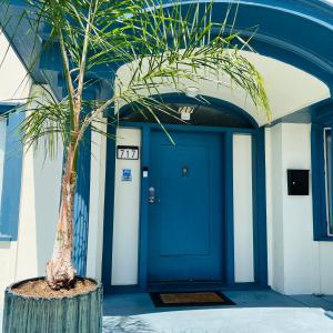 a palm tree in front of a blue door at The Wilshire Metro in Los Angeles