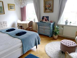 a bedroom with a bed with a blue dresser and a table at B&B Lilla Lotten in Östersund