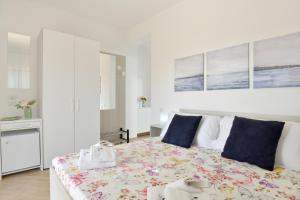 - une chambre blanche avec un grand lit et des oreillers bleus dans l'établissement B&b Il sogno, à Santa Maria di Castellabate