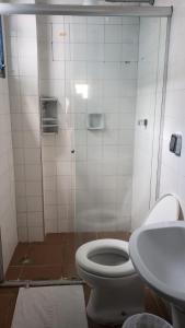 a bathroom with a toilet and a sink at Hotel Nevada Ubatuba in Ubatuba