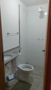 a bathroom with a white toilet and a sink at Star Hotel 205 Apenas diferente in Juiz de Fora