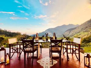een tafel en stoelen met uitzicht op de bergen bij The Capoe House in Haputale