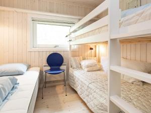 DronningmølleにあるHoliday Home Tårnfalkevejのベッドルーム1室(二段ベッド2台、青い椅子付)