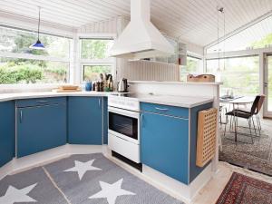 DronningmølleにあるHoliday Home Tårnfalkevejの床に青いキャビネットと星付きのキッチンが備わります。