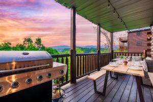 een grill en een tafel op een terras met uitzicht bij Bear Time Cabin - Scenic Mountain View, Firepit, Hot Tub, Theater, 4BR 3BA Sleeps 14 in Sevierville