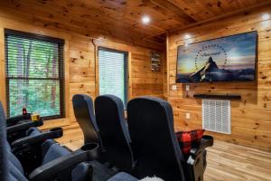 een bioscoopzaal met stoelen en een groot scherm bij Bear Time Cabin - Scenic Mountain View, Firepit, Hot Tub, Theater, 4BR 3BA Sleeps 14 in Sevierville