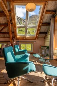 a room with chairs and a table and a window at Feriehus med flott havutsikt ved Hauklandstranden in Leknes
