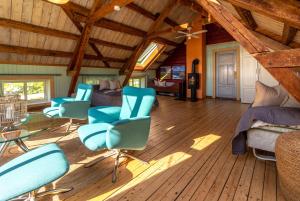 a living room with blue chairs and a bed at Feriehus med flott havutsikt ved Hauklandstranden in Leknes