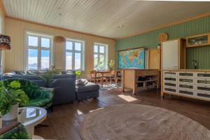 a living room with a couch and a table at Feriehus med flott havutsikt ved Hauklandstranden in Leknes